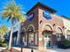 Corner view of Naples Soap Company, showcasing the brick facade, arched windows, and vibrant signage with a palm tree at 3095 Key Lime Loop, Kissimmee, FL 34747