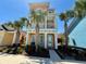 Three-story home with inviting front porch, dual entry doors, and lush landscaping at 3095 Key Lime Loop, Kissimmee, FL 34747