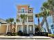 Charming three-story home with balconies and colorful exterior paint, surrounded by lush palm trees in a tropical setting at 3095 Key Lime Loop, Kissimmee, FL 34747