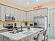 Modern kitchen with stainless steel appliances, island with seating, and gray cabinetry at 3095 Key Lime Loop, Kissimmee, FL 34747