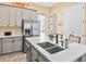 Bright kitchen with stainless steel refrigerator and island with sink and seating at 3095 Key Lime Loop, Kissimmee, FL 34747