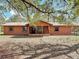 Charming single-story home featuring a metal roof and a cozy front porch with stone accents at 31926 Stearns Dr, Eustis, FL 32736