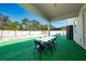 Inviting outdoor space featuring an extended covered patio, table, and artificial turf lawn at 3252 Jackson Bluff Way, Clermont, FL 34711