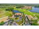 Aerial view of the golf course community featuring a clubhouse with meticulous landscaping and golf cart parking at 3621 Casello Dr, New Smyrna Beach, FL 32168