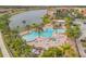 Lovely community pool with connected hot tub, tables, chairs and palm trees, with a beautiful lake view at 3621 Casello Dr, New Smyrna Beach, FL 32168