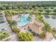 Community pool aerial showcasing lush palm trees, amenities and clubhouse, nestled in a tropical setting at 3621 Casello Dr, New Smyrna Beach, FL 32168