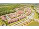 Wide aerial perspective of a community with townhomes, trees, ponds and roadways at 3621 Casello Dr, New Smyrna Beach, FL 32168