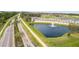 Aerial view of Venetian Bay entrance sign along a road with a water feature and palm trees in a golf course community at 3621 Casello Dr, New Smyrna Beach, FL 32168