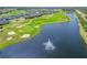 An aerial view highlights the golf course and waterfront homes in the Venetian Bay community, including a lake with a fountain at 3621 Casello Dr, New Smyrna Beach, FL 32168