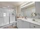 Bright bathroom with a glass-enclosed shower, white vanity, and a large mirror at 3621 Casello Dr, New Smyrna Beach, FL 32168