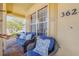 Cozy front porch featuring wicker seating with blue cushions and brick flooring at 3621 Casello Dr, New Smyrna Beach, FL 32168