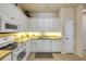 Bright kitchen features white cabinetry, stainless steel appliances, and tile flooring at 3621 Casello Dr, New Smyrna Beach, FL 32168