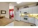 Functional kitchen showcasing white appliances, light cabinetry, and adjacent dining area for easy serving at 3621 Casello Dr, New Smyrna Beach, FL 32168
