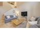Open-concept living room with staircase features comfortable seating, a clock, and TV for relaxation at 3621 Casello Dr, New Smyrna Beach, FL 32168