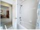 Clean bathroom featuring a shower-tub combo with white tile surround and modern shower head fixture at 3635 Kingswood Ct, Clermont, FL 34711