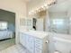 Clean bathroom with tile floor, modern vanity, large mirror, and walk-in shower at 3635 Kingswood Ct, Clermont, FL 34711