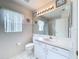 Bright bathroom showcasing a toilet, vanity with ample storage, and an illuminated mirror at 3635 Kingswood Ct, Clermont, FL 34711