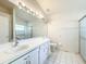 Clean bathroom with tile floor, modern vanity, large mirror, and walk-in shower at 3635 Kingswood Ct, Clermont, FL 34711