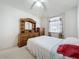 Bedroom featuring wood furniture set, neutral carpet and a sunlit window with decorative curtains at 3635 Kingswood Ct, Clermont, FL 34711