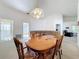 Open concept dining room with carpet, wooden table and chairs, and view to the living room at 3635 Kingswood Ct, Clermont, FL 34711