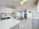 Bright kitchen featuring white cabinets, eat-in nook and view of the laundry room at 3635 Kingswood Ct, Clermont, FL 34711