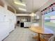 Bright kitchen featuring eat-in table, white cabinets, and tile floors at 3635 Kingswood Ct, Clermont, FL 34711