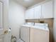 Functional laundry room featuring washer, dryer, and upper cabinets for organized storage at 3635 Kingswood Ct, Clermont, FL 34711