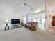 Bright living room featuring neutral carpet, ceiling fan, and seamless flow to the kitchen at 3635 Kingswood Ct, Clermont, FL 34711