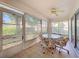Enclosed sun room with a glass table and seating surrounded by bright, sun-filled windows at 3635 Kingswood Ct, Clermont, FL 34711