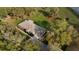 Aerial view of a single story home with a long driveway, surrounded by trees and a lush green lawn at 40610 Babb Rd, Umatilla, FL 32784