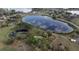 Drone shot shows the home's location near a pond and lake, surrounded by lush greenery, and clear blue skies at 40610 Babb Rd, Umatilla, FL 32784