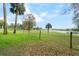 Scenic view of a large backyard, trees, and lake beyond a fence at 40610 Babb Rd, Umatilla, FL 32784