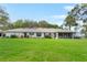Sprawling backyard with lush green lawn and a covered patio at 40610 Babb Rd, Umatilla, FL 32784