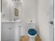 Cozy half bathroom with a white vanity, toilet with a blue seat cover, and neutral-colored flooring at 40610 Babb Rd, Umatilla, FL 32784