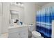 Bright bathroom offers vanity with a sink, a toilet, and a shower with a blue curtain at 40610 Babb Rd, Umatilla, FL 32784