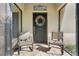 Welcome to the front door, with comfortable seating, a festive wreath, and a screen door for fresh air at 40610 Babb Rd, Umatilla, FL 32784