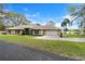 Charming single story home featuring a well-manicured lawn, mature trees, and a long driveway leading to an attached two car garage at 40610 Babb Rd, Umatilla, FL 32784