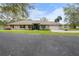 Charming single-story home with manicured front lawn, dark shutters, brick paver walkway, two-car garage and view of pond at 40610 Babb Rd, Umatilla, FL 32784