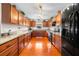 Spacious kitchen featuring hardwood floors, wooden cabinets, granite countertops, and modern black appliances at 40610 Babb Rd, Umatilla, FL 32784