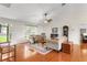 Open living room with wood floors, ceiling fan, sofas, and views of the front yard through sheer curtains at 40610 Babb Rd, Umatilla, FL 32784