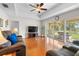 Comfortable living room with hardwood floors, a ceiling fan, a TV, and access to a screened patio at 40610 Babb Rd, Umatilla, FL 32784