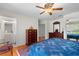 Charming main bedroom boasts hardwood floors, ceiling fan, dresser, and ensuite bathroom at 40610 Babb Rd, Umatilla, FL 32784