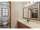 Traditional bathroom with a vanity, toilet, and a window for natural light at 425 N Pine Meadow Dr, Debary, FL 32713
