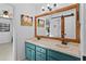 Bathroom featuring double sinks with teal cabinets, wood mirror, and barn door at 425 N Pine Meadow Dr, Debary, FL 32713
