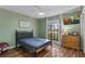 Cozy bedroom with natural light, hardwood flooring, and window view of the yard at 425 N Pine Meadow Dr, Debary, FL 32713