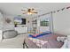 Well-lit bedroom with mounted TV, ceiling fan, desk, beanbag, and decorated with sports flags at 425 N Pine Meadow Dr, Debary, FL 32713