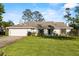 Charming single-story home with a manicured lawn, two-car garage, and classic architectural details at 425 N Pine Meadow Dr, Debary, FL 32713