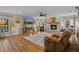 Inviting living room with hardwood floors, a brick fireplace, and a large TV at 425 N Pine Meadow Dr, Debary, FL 32713