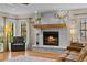 Cozy living room with a painted brick fireplace, hardwood floors, and a comfortable sitting area at 425 N Pine Meadow Dr, Debary, FL 32713