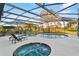 Screened-in pool with hot tub, lounge chairs, and view of lush backyard at 425 N Pine Meadow Dr, Debary, FL 32713